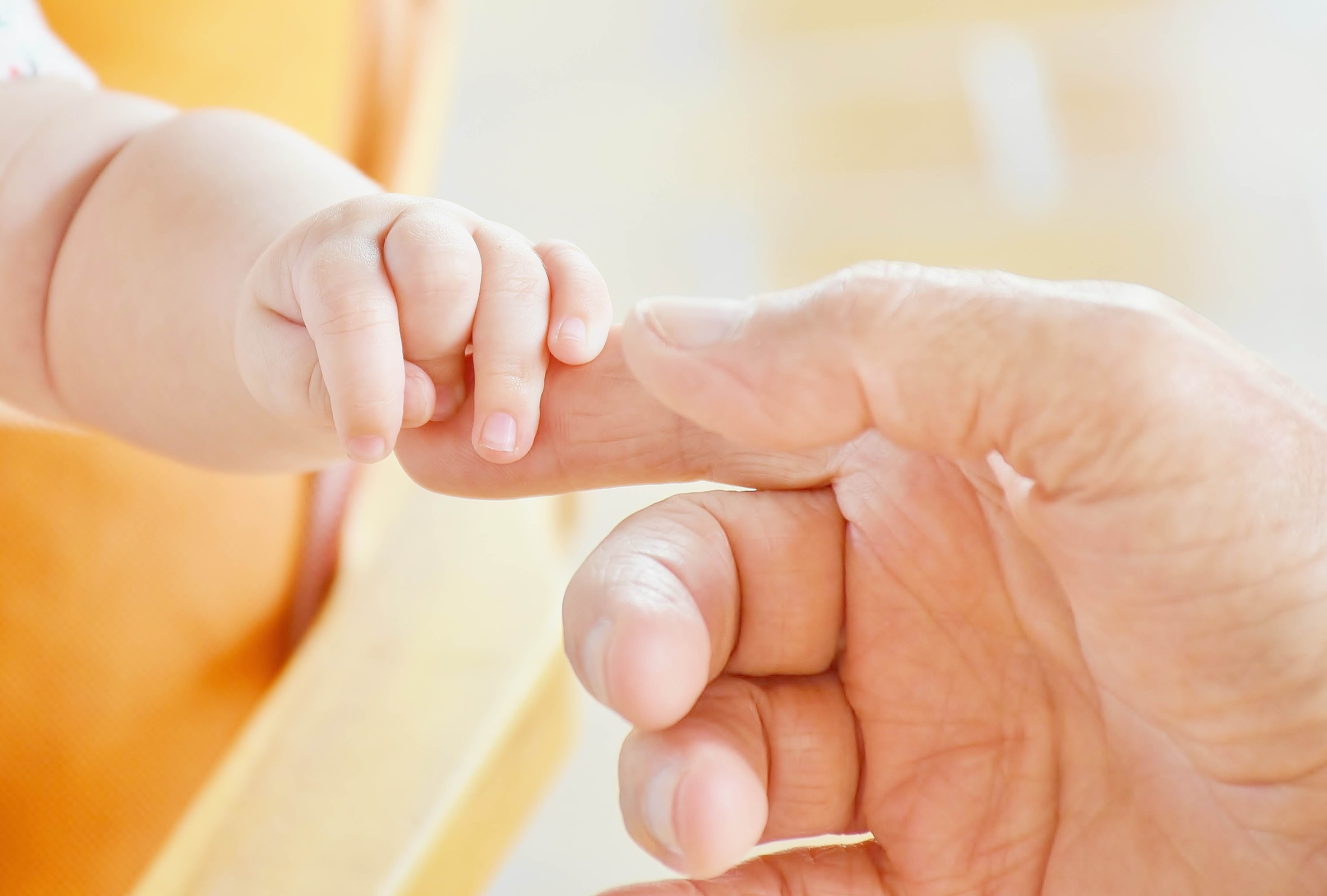Baby clinging onto parent's finger header for Perinatal Depression and Anxiety post