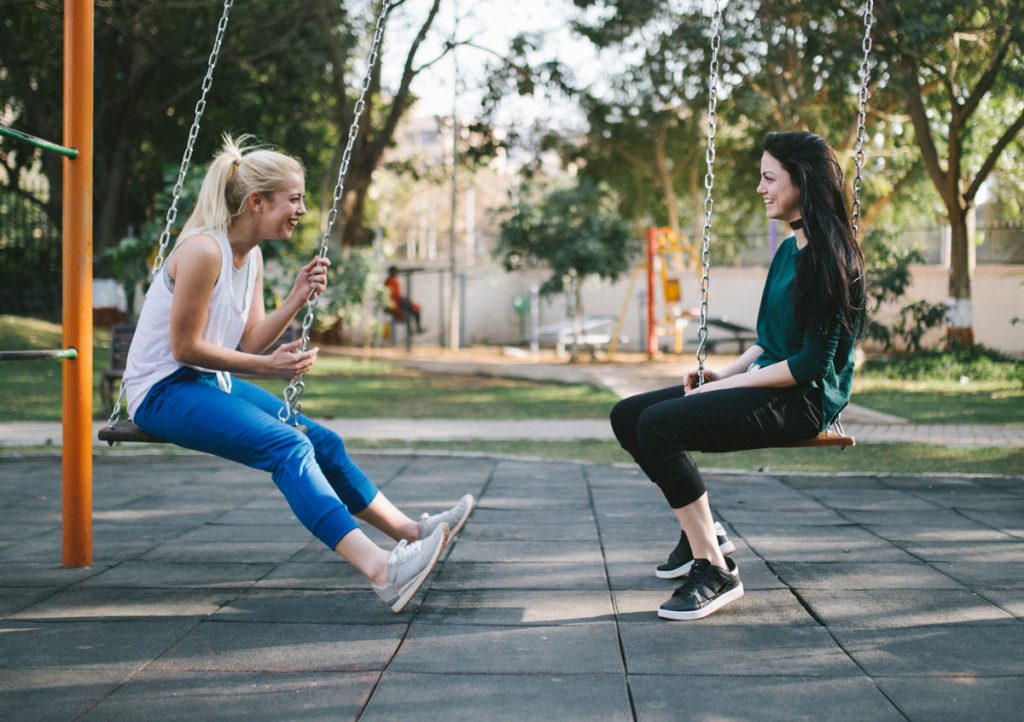 YACWA Two teenage girls on swings talking about mental health and positive choices