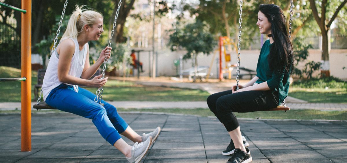 YACWA Two teenage girls on swings talking about mental health and positive choices